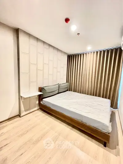 Modern bedroom with stylish decor and natural light, featuring a cozy bed and elegant curtains.