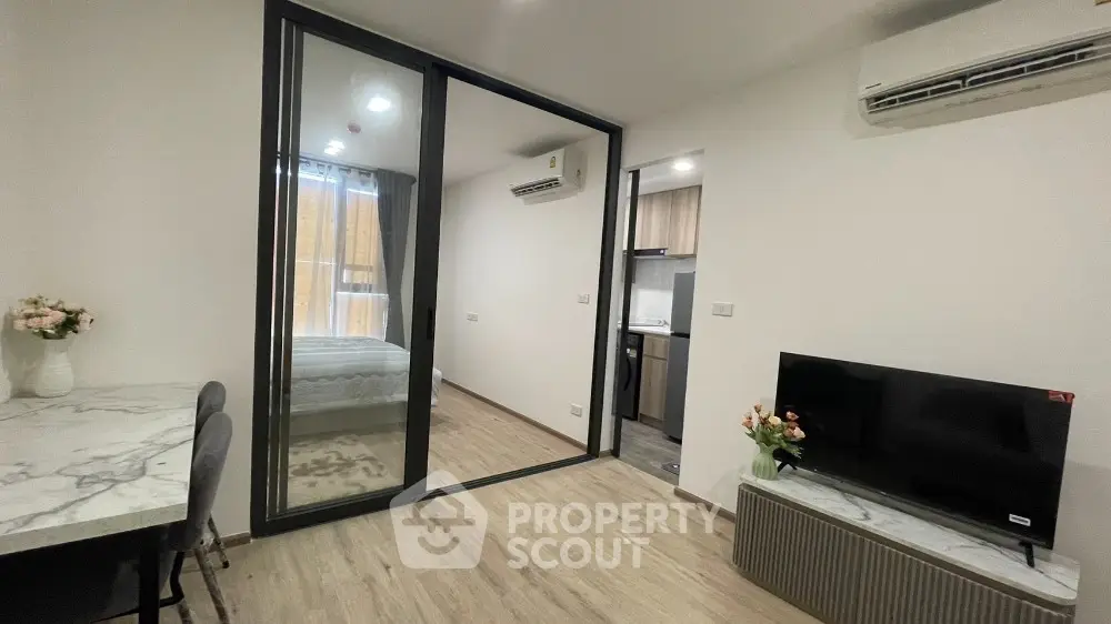 Modern apartment interior with glass partition, stylish decor, and efficient layout.