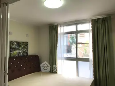Cozy bedroom with large window and elegant curtains in modern apartment