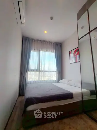 Modern bedroom with large window and stylish decor in a high-rise apartment.