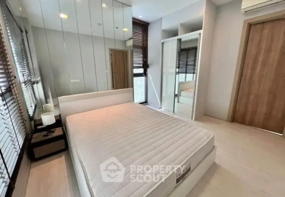 Modern bedroom with mirrored wall and sleek design in a contemporary apartment.