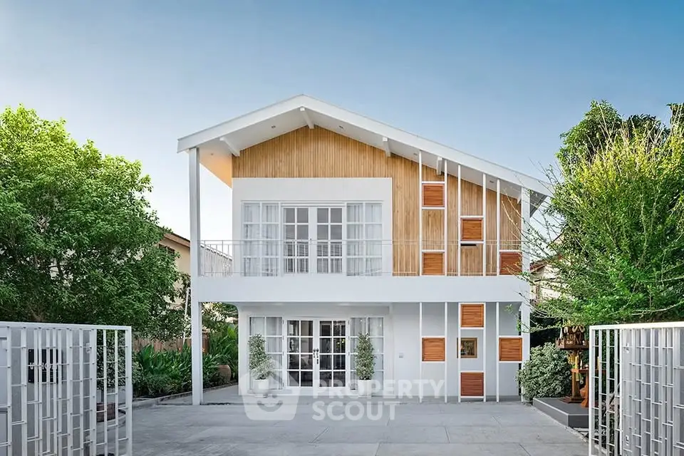 Modern two-story house with sleek design and lush greenery