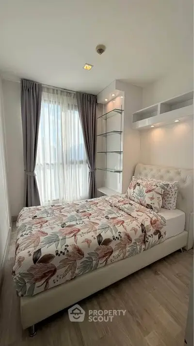 Cozy bedroom with floral bedding and natural light in modern apartment