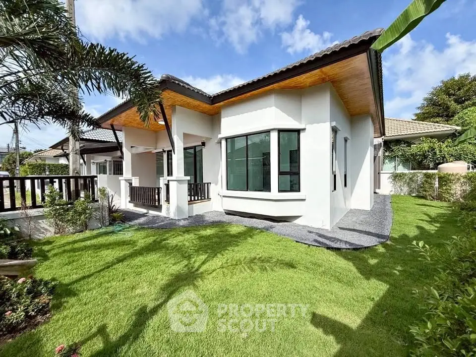 Charming single-story house with lush green lawn and modern architectural design.