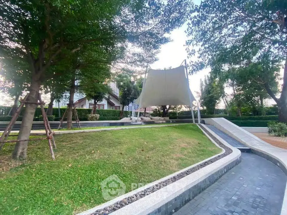 Charming garden area with lush greenery and modern pathways in a serene residential setting.