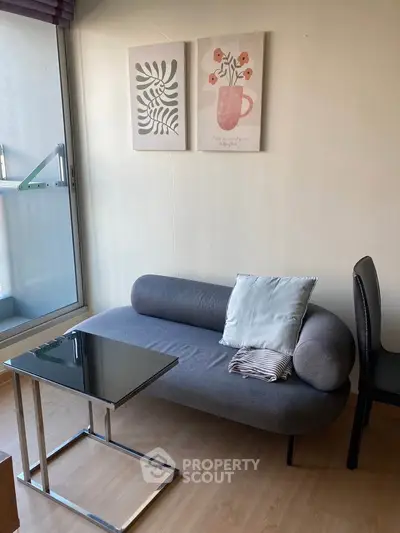 Cozy living room with modern sofa and glass coffee table, perfect for relaxation.