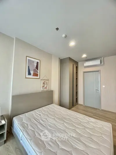 Modern bedroom with minimalist design, featuring a comfortable bed and stylish decor in a contemporary apartment.