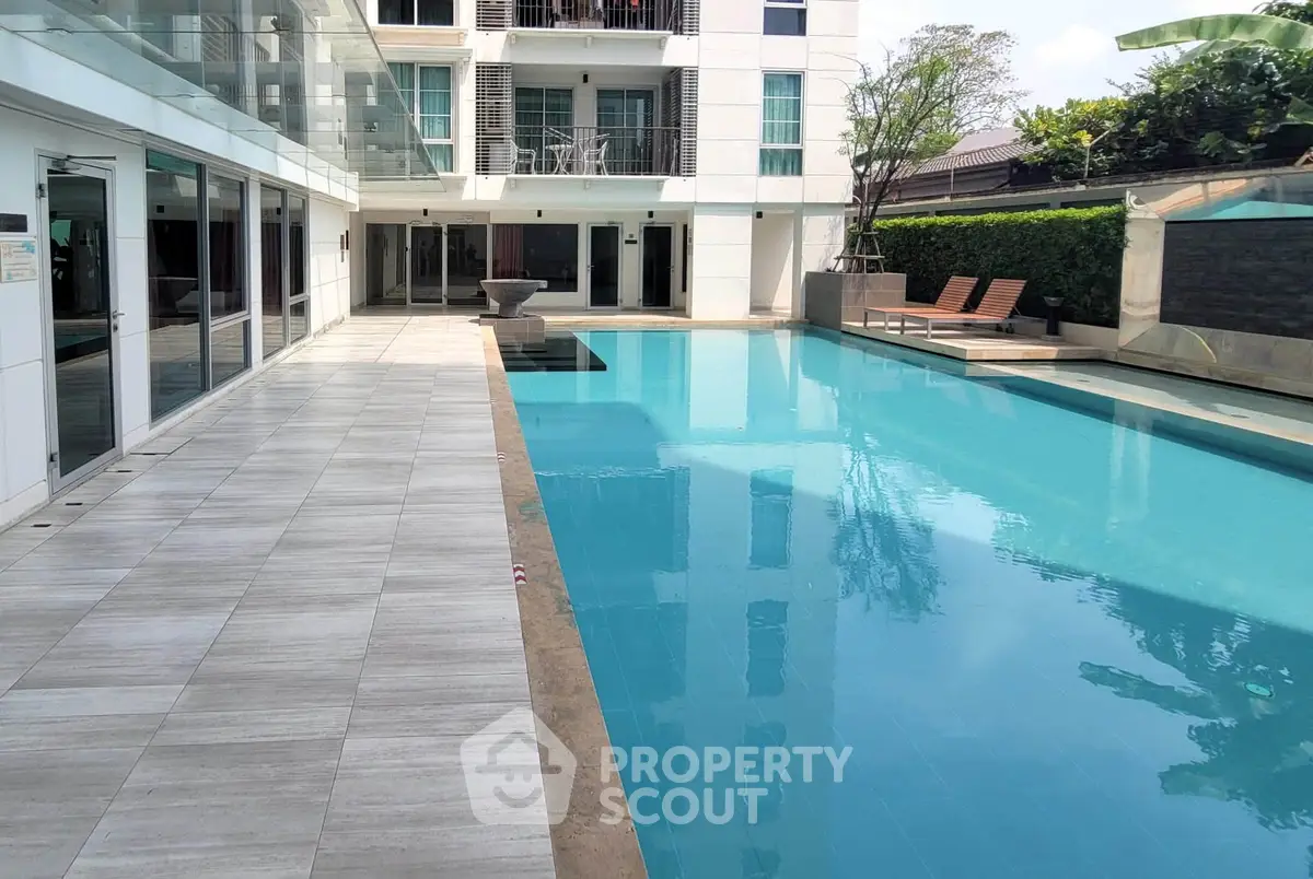 Luxurious apartment complex with a pristine swimming pool and modern design.