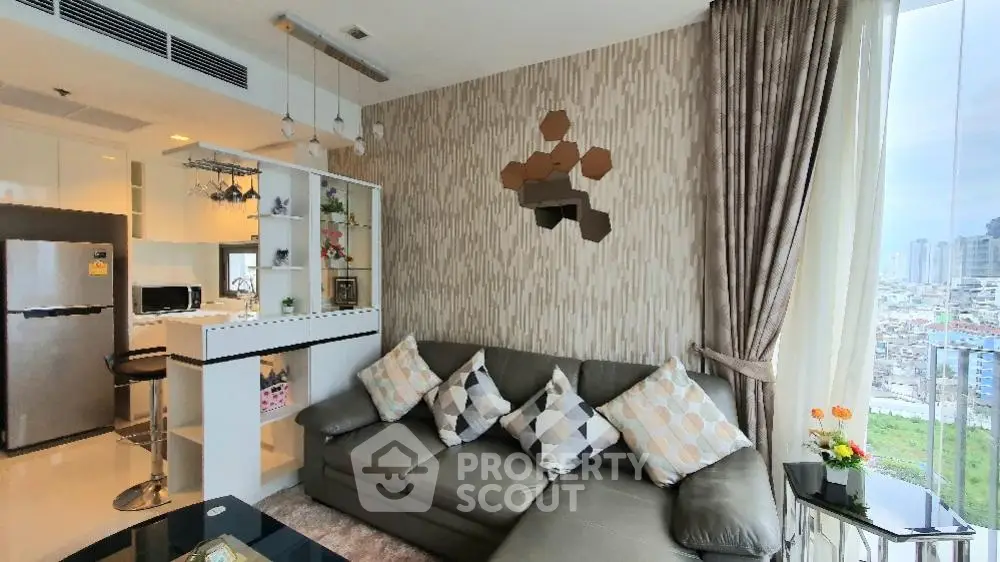 Modern living room with stylish decor and city view, featuring a cozy sectional sofa and open kitchen layout.
