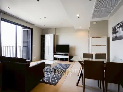 Modern living room with stylish furniture and open balcony view in a contemporary apartment.