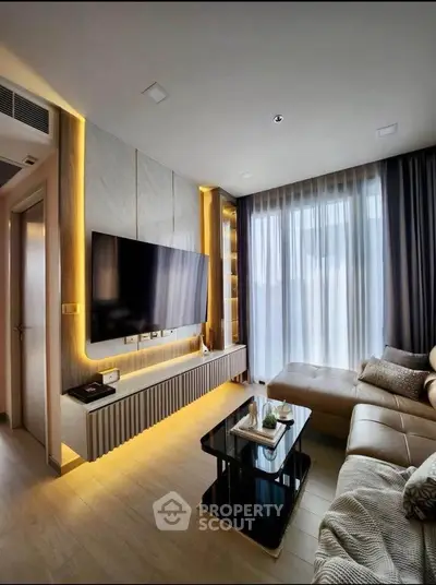 Modern living room with sleek design, large TV, and cozy sectional sofa.