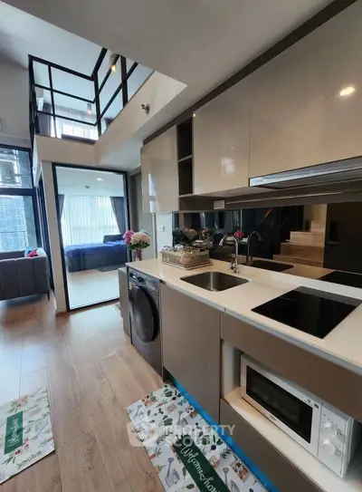 Modern open-layout kitchen with sleek appliances and stylish decor in a contemporary apartment.