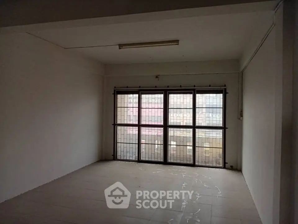 Spacious empty room with large windows and tiled flooring, ideal for customization.