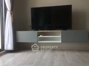 Modern living room with sleek TV unit and large window for natural light.