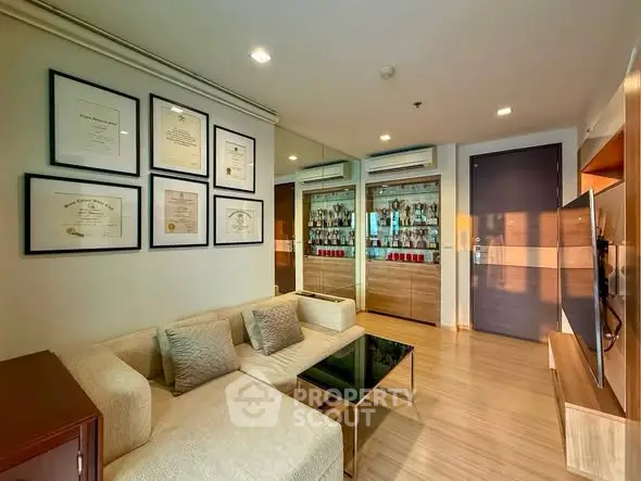 Modern living room with elegant decor and wall art, featuring a cozy beige sofa and glass coffee table.