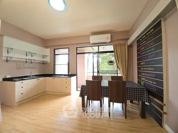 Spacious kitchen with dining area and open layout, featuring modern decor and natural light.