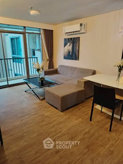 Modern living room with stylish decor and balcony access in a cozy apartment.