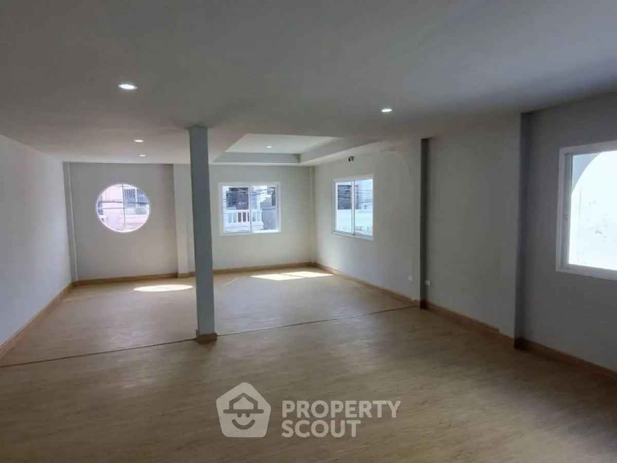 Spacious open-plan living area with large windows and modern lighting