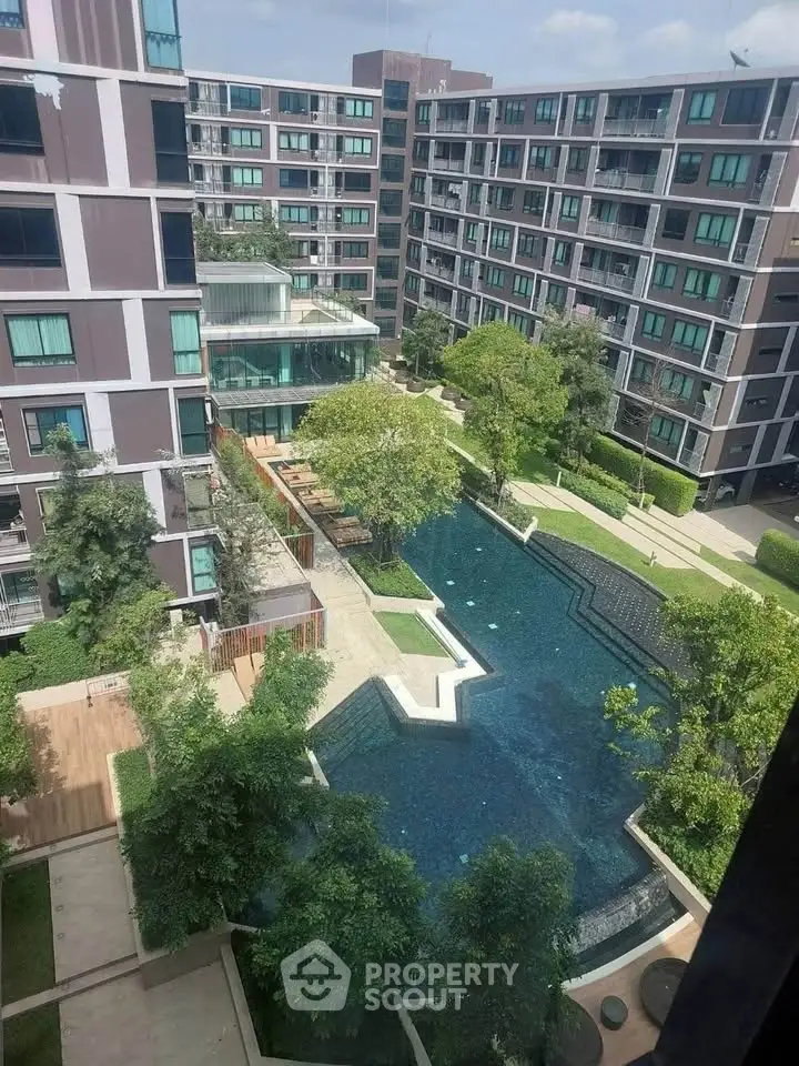 Modern apartment complex with lush greenery and a stylish swimming pool view.
