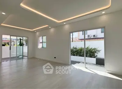 Spacious modern living room with large windows and elegant ceiling lights