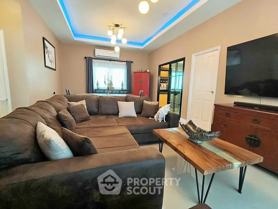 Spacious living room with modern decor, large sectional sofa, and stylish lighting.