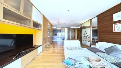 Spacious modern living room with stylish decor and large TV, perfect for relaxation and entertainment.