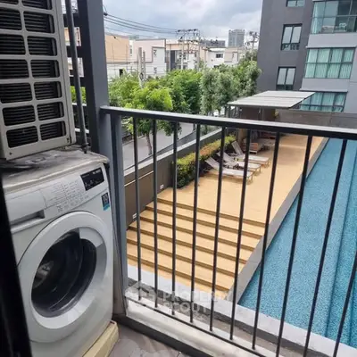 Modern apartment balcony with pool view and washing machine
