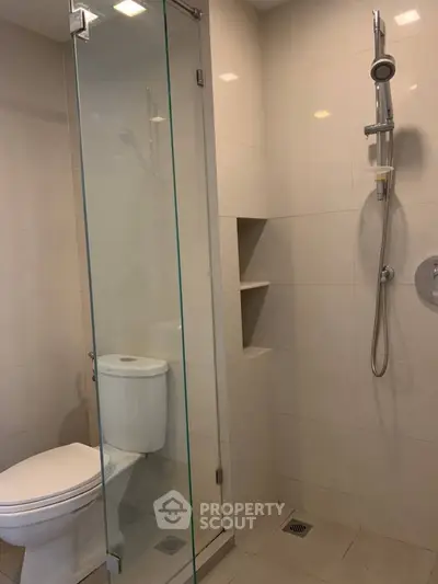 Modern bathroom with glass shower and sleek fixtures in a contemporary apartment.