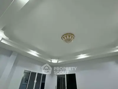 Elegant ceiling design with modern lighting in a spacious room, featuring a stylish chandelier centerpiece.