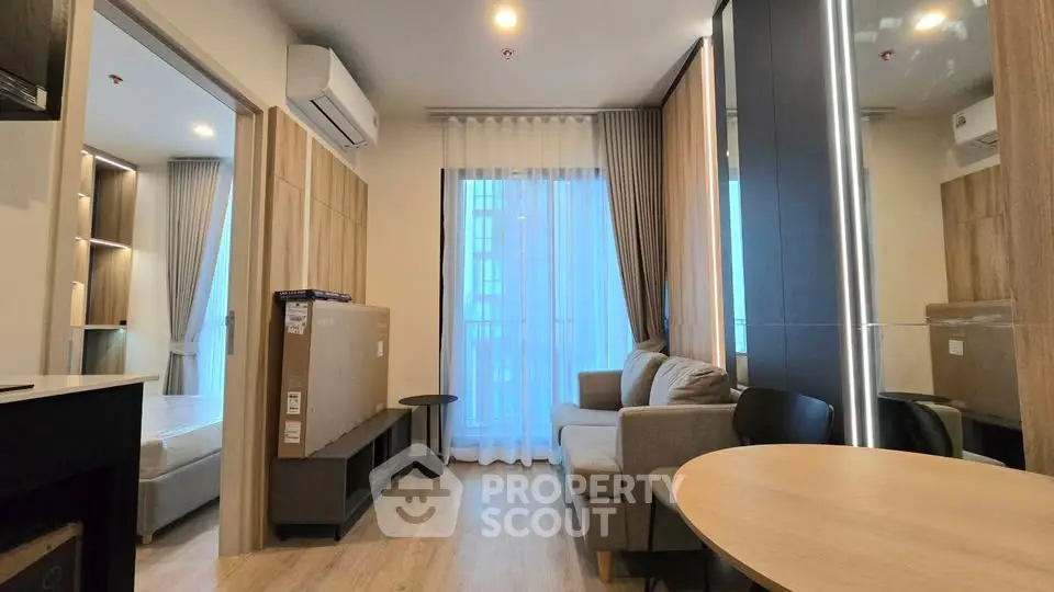 Modern living room with natural light, cozy sofa, and stylish decor in a contemporary apartment.
