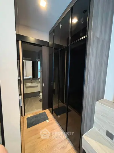 Modern bathroom with sleek black cabinetry and wood flooring