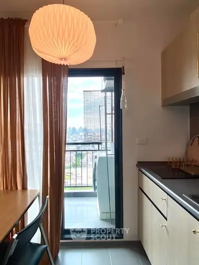 Modern kitchen with balcony view and washing machine, featuring sleek cabinetry and stylish lighting.