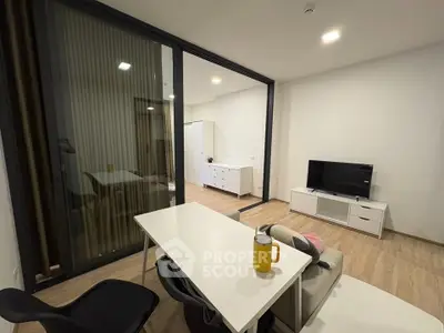 Modern living room with sleek furniture and glass partition in contemporary apartment.