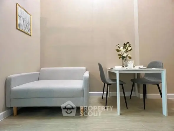 Modern minimalist living room with cozy sofa and dining table setup.