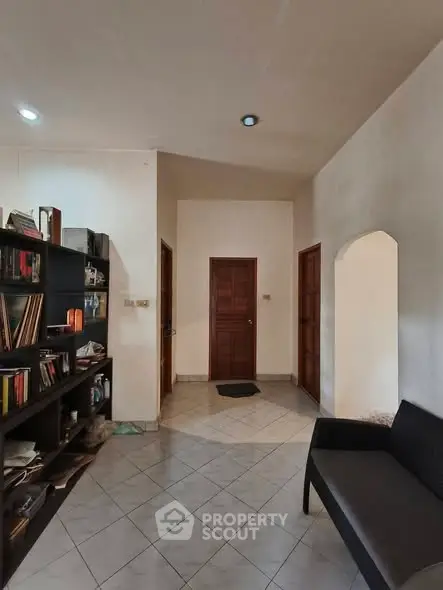 Cozy interior hallway with bookshelf and seating area, perfect for a welcoming home atmosphere.