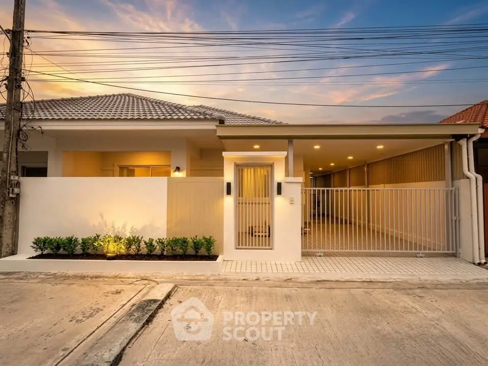 Modern single-story house with sleek design and spacious carport at sunset.