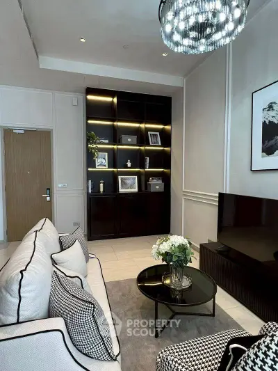 Elegant living room with modern decor, featuring a stylish chandelier and built-in shelving.