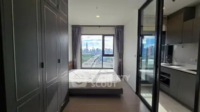 Modern bedroom with city view, featuring sleek design and ample natural light.