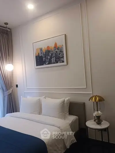 Elegant bedroom with modern decor and cityscape artwork, featuring cozy bedding and stylish lighting.