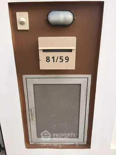Modern exterior mailbox and utility access panel on a stylish building facade.