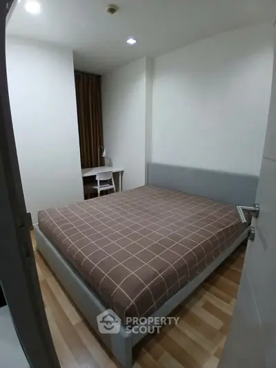 Cozy bedroom with modern decor and study area, perfect for urban living.