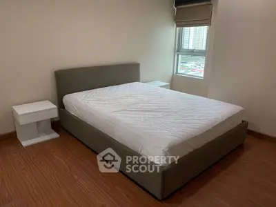 Spacious bedroom with modern bed and city view window in stylish apartment.