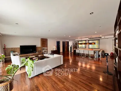 Spacious open-plan living room with elegant hardwood floors and modern furnishings.