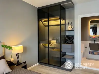 Modern bedroom with sleek glass wardrobe and stylish bathroom view