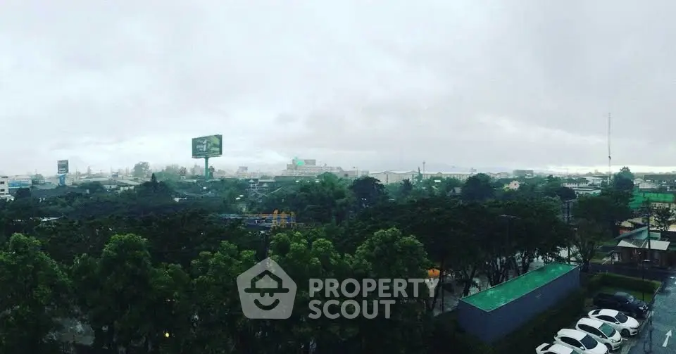 Panoramic view of urban landscape with lush greenery and overcast sky.