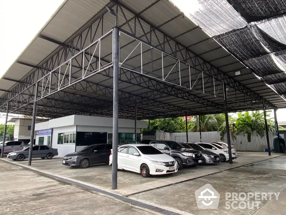 Spacious covered parking area with multiple cars and modern structure.