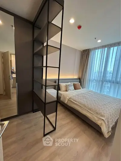 Modern bedroom with stylish shelving and large window offering city views.