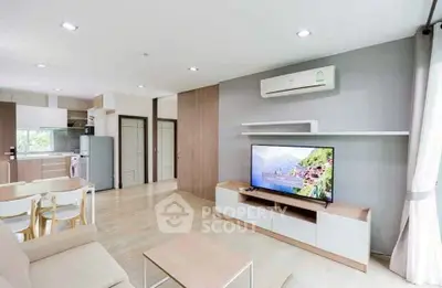 Modern open-plan living room with sleek furniture and integrated kitchen appliances.