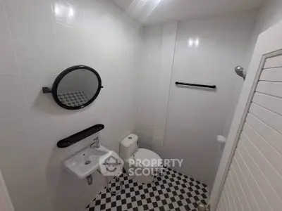 Modern minimalist bathroom with checkered floor tiles and sleek fixtures.