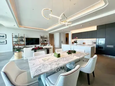 Luxurious open-plan living and dining area with modern lighting and elegant marble table.
